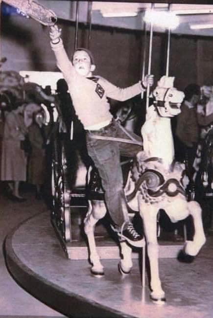 A boy reaching for the brass ring on the Nunley's carousel