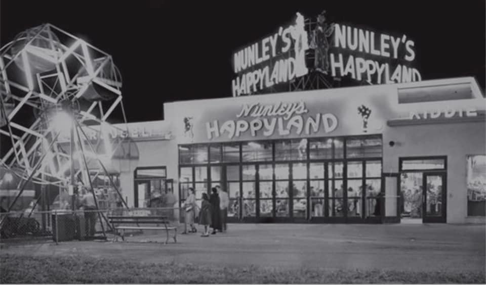 Nunley's Happyland at night with neon signs and Ferris wheel